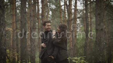 在森林里相爱的一对。 初秋，林中其晴.. 女孩拥抱她的男人。 他们拥抱，拥抱